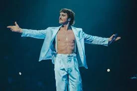 Editorial gallery of Benson Boone styled in misty blue and lavender ensembles accented with silver sparkle, highlighting bluebell, lavender mist, storm gray, cool teal, and soft navy.