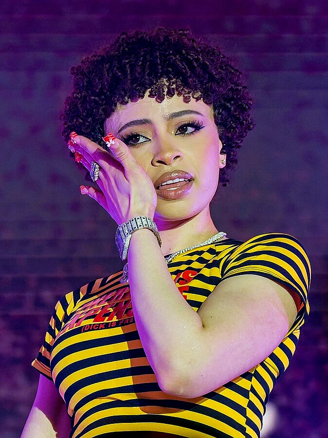 Ice Spice wearing saturated autumn looks with molten metallics, showcasing neon tangerine, persimmon, cobalt, molten gold, and deep teal from the Vibrant Autumn palette.