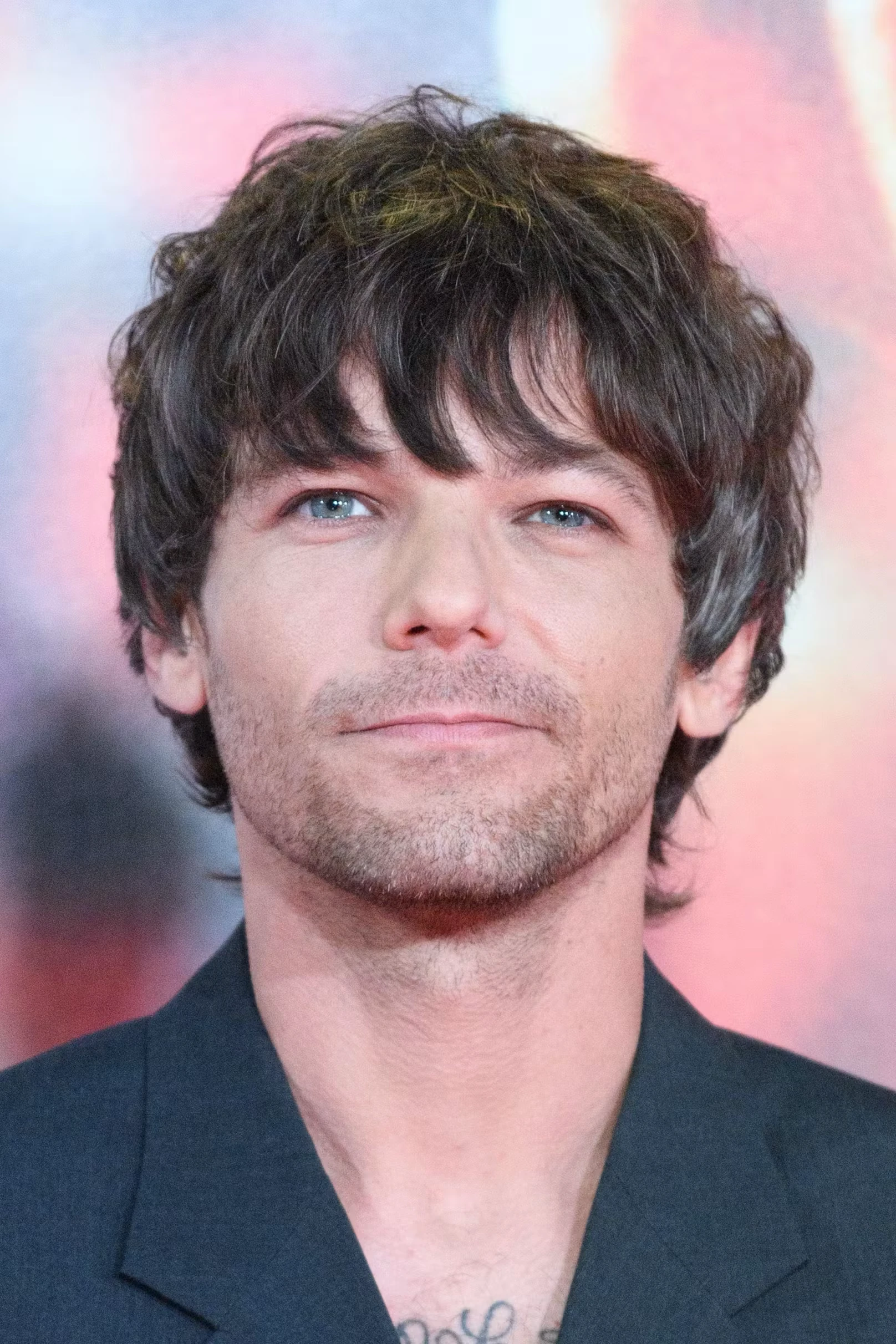 Louis Tomlinson wearing velvety pastel looks with cool-muted tones, showcasing heather gray, dusty mauve, mist blue, slate green, and antique silver from the Soft Summer palette.